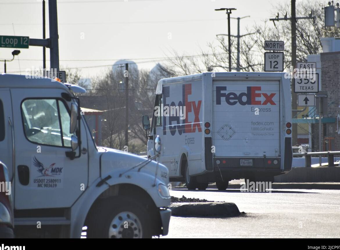 Conducción del camión de reparto de FedEx, vista alejándose de la cámara...